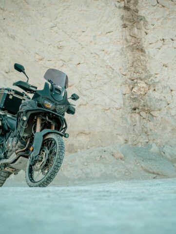 Moto trail équipée de crash bars roulant sur une piste près d’une grotte