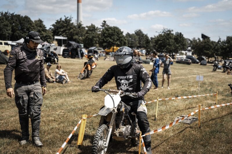 Ambiance conviviale entre participants et motos lors de l'ACT Camp 2026